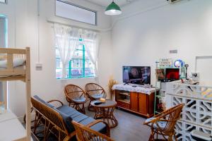 a living room with chairs and a table and a tv at Aru corner 6B1BR Tanjung aru town kota kinabalu in Kota Kinabalu