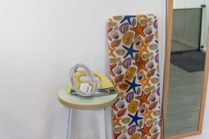 a pair of shoes sitting on a stool in front of a mirror at Aru corner 6B1BR Tanjung aru town kota kinabalu in Kota Kinabalu