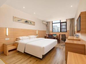 a bedroom with a large white bed and a desk at City Comfort Inn Huangshi Daye Tongluowan Business Street in Huangshi +135 photos