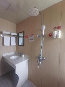 une salle de bain avec un lavabo et une douche dans l'établissement Jun Hotel Anhui Bozhou Lixin County Wenzhou Road, à Chundian
