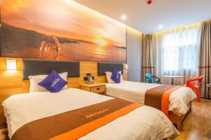 a hotel room with two beds and a painting on the wall at Jun Hotel Gansu Lanzhou Chengguan District Zhangye Road Walking Street in Lanzhou