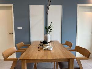 スリ・カンバンガンにあるModern Suite in Seri Kembangan Nearby MRTのダイニングルームテーブル(椅子、花瓶付)