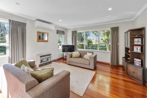 Una sala de estar con dos sofás y un televisor. en Bell Cottage - Oakura Holiday Home, en New Plymouth
