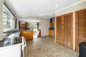 Una cocina con gabinetes de madera y encimera. en Bell Cottage - Oakura Holiday Home, en New Plymouth
