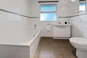 Un baño con bañera, inodoro y lavabo. en Bell Cottage - Oakura Holiday Home, en New Plymouth 18 fotos más