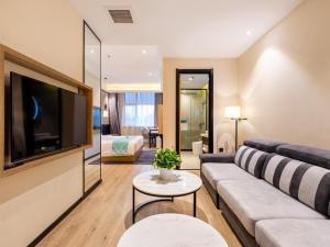 een woonkamer met een bank en een tv bij Xana Lite Tianjin Ninghe Trade Development Zone in Ninghe