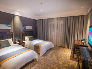 a hotel room with two beds and a flat screen tv at Shell Hotel Tai'an Feicheng Longshan Road in Muzhuang +167 photos