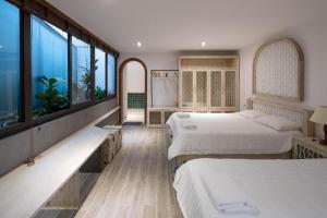 ein Hotelzimmer mit 2 Betten und großen Fenstern in der Unterkunft Nap Am - Dalat in Ấp Kim Thạch