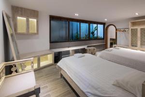 Un dormitorio con dos camas y una gran ventana. en Nap Am - Dalat, en Ấp Kim Thạch