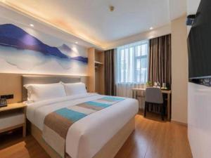 a hotel room with a large bed and a desk at VX Hotel Xiamen Siming District Xiamen University Huandao Road in Xiamen