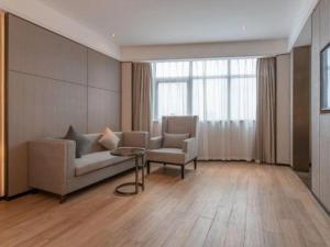 a living room with a couch and a chair and a table at Echeng Hotel Nanning Huqiu Metro Station in Nanning