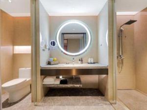 a bathroom with a sink and a toilet and a mirror at GreenTree Eastern Hotel Nanning Minzhu Road Chaoyang Plaza in Shanglin +186 photos