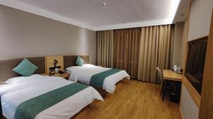 a hotel room with two beds and a television at Green Tree Inn Express Shandong Dezhou Qihe County Qiqifa in Sangzidian +131 photos