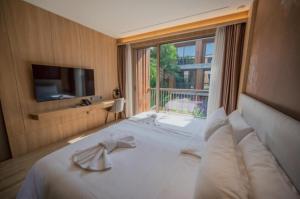 a hotel room with a bed with a large window at Riverton Hotel in Samut Songkhram +48 photos