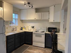 哥德伍德Chalet Gallery - Enjoy Two Units with this Chalet in the Heart of Alyeska - Walk almost anywhere!的厨房配有白色橱柜和白色炉灶烤箱。