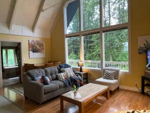 哥德伍德Chalet Gallery - Enjoy Two Units with this Chalet in the Heart of Alyeska - Walk almost anywhere!的带沙发和桌子的客厅