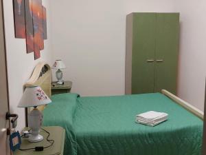 a bedroom with a green bed and a lamp at Alba Mozzafiato in Lanusei