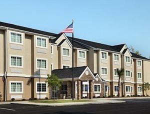 a large building with an american flag in front of it at Microtel Inn & Suites by Wyndham Columbia in Columbia