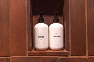two white bottles are sitting on a shelf at Cozy Retreat Amidst Boulders in Yucca Valley +44 photos