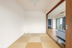 a living room with a door and a blue couch at Jintai House601 in Shiobaru