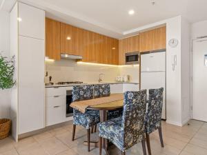 Una cocina con una mesa y sillas de madera. en Stylish Apartment with Rooftop BBQ & Spa Access, en Brisbane