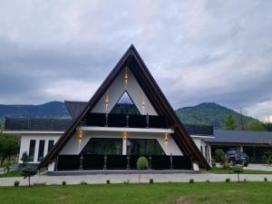 a large white building with a triangular roof at Vila Timeea in Statiunea Borsa
