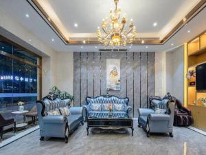 a living room with blue chairs and a chandelier at Borrman Hotel Nanning Anji Passenger Station Xijin Metro Station in Nanning