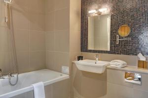 a bathroom with a sink and a tub and a mirror at Quy Mill Hotel & Spa, Cambridge in Cambridge