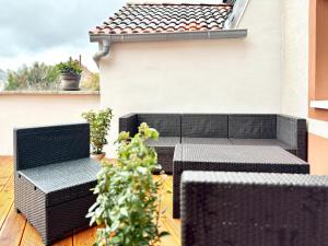 a patio with two chairs and plants on a building at COZEE - Spacious Apartment With Netflix in Kaiserslautern