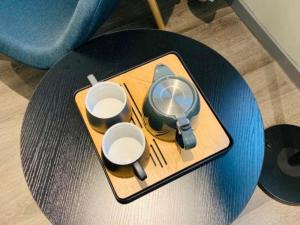 a tray with three cups and a juicer on a table at City Comfort Inn Hotel Wuhan Optics Valley Square Metro Station Zhongnan Minzu University in Wuhan
