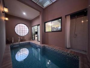 a bathroom with a large swimming pool with a shower at Villa Kyuri Lembang in Panjadakan