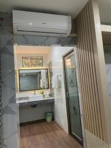 a bathroom with a sink and a mirror and a shower at Saysamphanh Hotel in Ban Nongkham