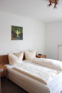ein Schlafzimmer mit einem großen Bett mit weißer Bettwäsche in der Unterkunft Apartmentcenter Koblenz in Koblenz