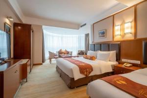 Una habitación de hotel con dos camas y un televisor. en Qingdao Blue Horizon Hotel Huangdao, en Huangdao 122 fotos más