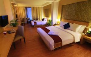 a hotel room with a large bed and a desk at The Axana Hotel in Kampungdurian