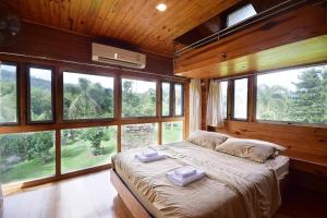 una camera da letto con un letto grande in una stanza con finestre di Nicslongstay Hotel a Ban Kom