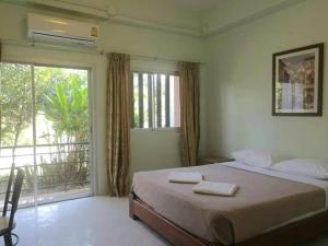 une chambre avec un lit et une grande fenêtre dans l'établissement Palm Hill Resort, à Khanom