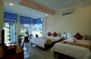 a hotel room with two beds and a window at Blue Beach Hotel Danang in Da Nang +161 photos