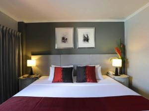 a bedroom with a large bed with red and black pillows at Regent Park Hotel in Phnom Penh
