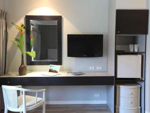 a room with a desk with a tv and a mirror at Regent Park Hotel in Phnom Penh