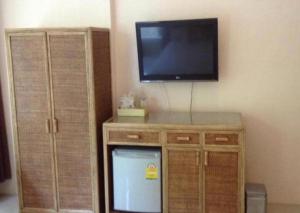 a flat screen tv on a wall with a tv on top at Magic House Hostel in Hua Hin
