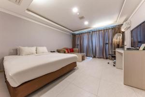 a bedroom with a bed and a tv in a room at Metro Tourist Hotel Cheonan in Cheonan
