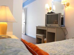 una camera con letto e TV su una scrivania di Hotel Galleria a Davao