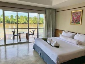 アムパワーにあるNopparat Garden Hotelのベッドルーム(ベッド1台、テーブル付)、バルコニーが備わります。 +124枚の写真