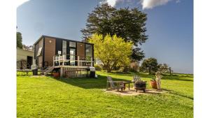 Ross CreekGold Meadows by Tiny Away的坐落在郁郁葱葱的绿色田野上的小房子