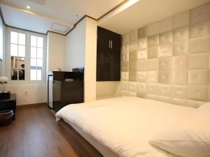 ソウルにあるMyeongdong Mom Houseのベッドルーム1室(白い大型ベッド1台付)