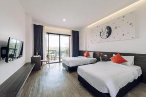 a hotel room with two beds and a television at PIMDARA HOTEL in Ban Kaeo