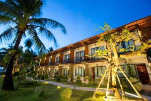 a building with palm trees in front of it at SEESEA RESORT in Amphoe Langu