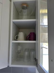 a cupboard filled with dishes and a wine glass at Maria apartment with Sauna Otta in Otta +13 photos