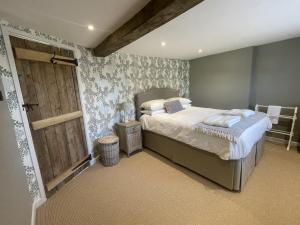 a bedroom with a bed and a wooden door at Wisteria Cottage - 2 bed near Bath & many NT sites in Holt